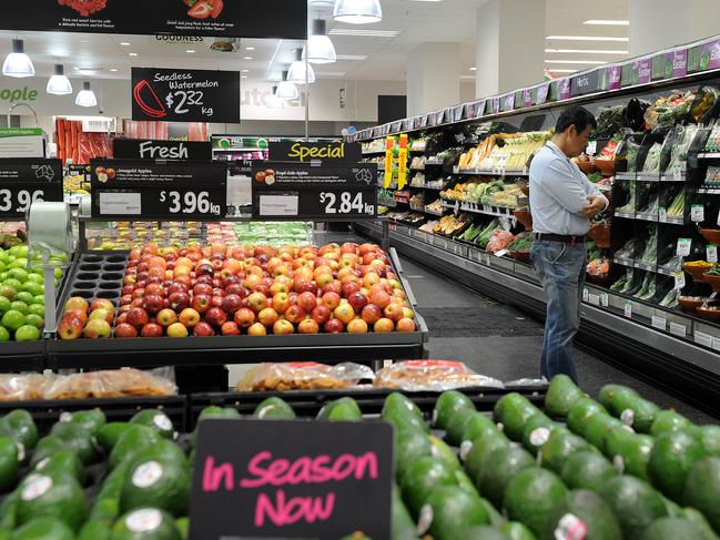 A shopper looks at produce in the fruit and vegetable section inside a Woolworths grocery store in Brisbane, Tuesday, April 19, 2011. (AAP Image/Dave Hunt) NO ARCHIVING