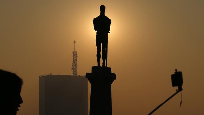 A girl takes a selfie during sunset over monument The Victor, a distinctive symbol of Belgrade on Kalemegdan fortress.