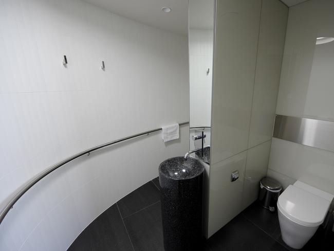 The bathroom is set behind a curved timber wall.