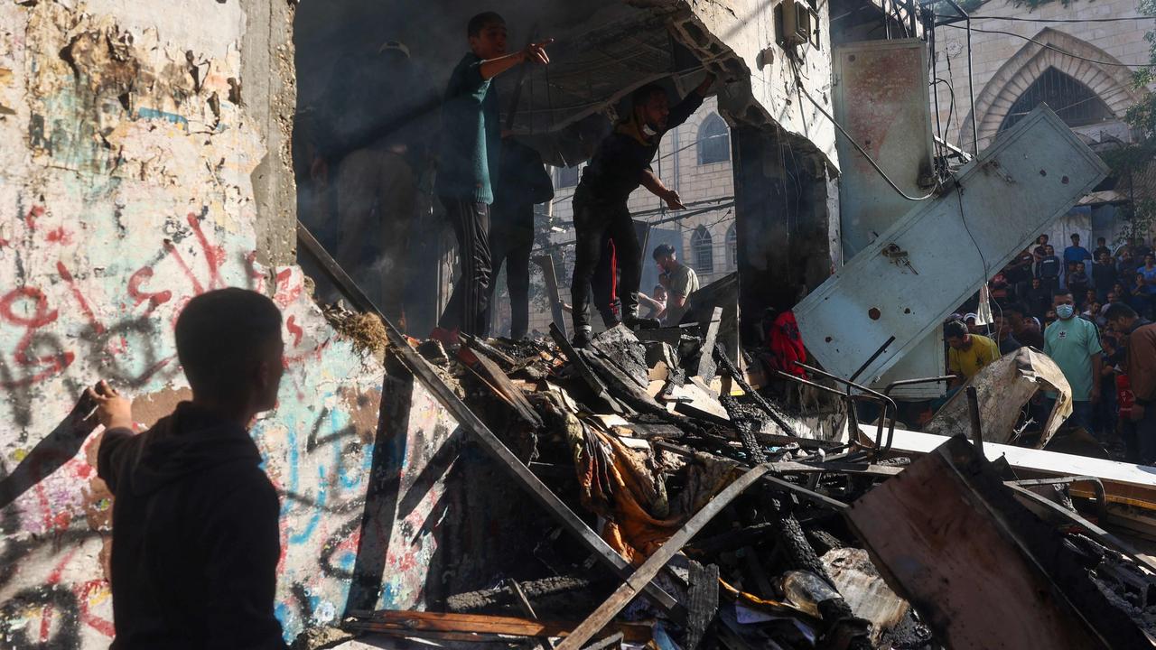 Palestinians check the destroyed Maghazi Camp Services Club building following an Israeli strike on the Maghazi refugee camp in the Gaza Strip on October 24, 2024, amid the ongoing war between Israel and Hamas.  (Photo by Eyad BABA / AFP)