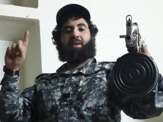 Clad in military fatigues, Sydney man Ahmed Merhi holds an assault rifle.