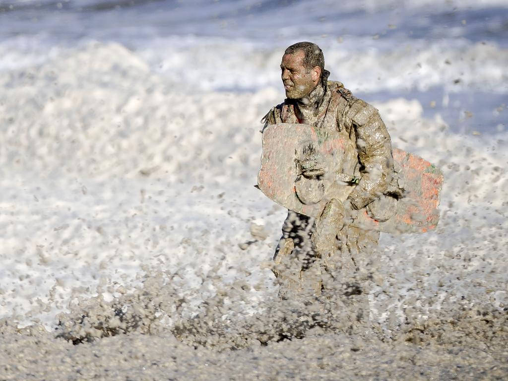 A rescue worker stands in rough waters during the resumed search for missing water sports participants at Scheveningen.