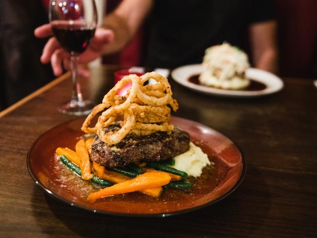 Oleada restaurant’s signature dish a succulent King Island beef steak with blue-cheese sauce topped with onion rings and accompanied by fresh locally sourced vegetables. Picture: STU GIBSON/TOURISM TASMANIA