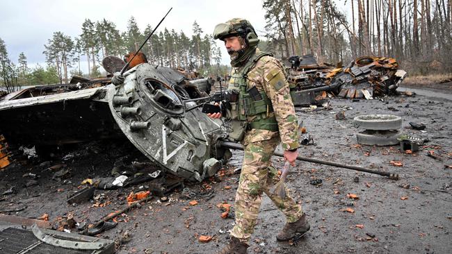 A Ukrainian serviceman walks past destroyed Russian tanks not far from the Ukrainian capital of Kyiv. Picture: AFP.