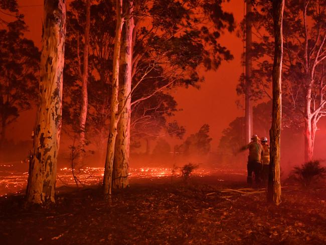 Firefighters inspect the area as they battle against bushfires around the town of Nowra in the Australian state of New South Wales on December 31, 2019. - Thousands of holidaymakers and locals were forced to flee to beaches in fire-ravaged southeast Australia on December 31, as blazes ripped through popular tourist areas leaving no escape by land. Picture: Saeed Khan/AFP