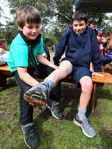 <p>Felix Saunders, 8, bandaging Noah McBrien, 10, for snake bite. Picture: Kim Eiszele</p>