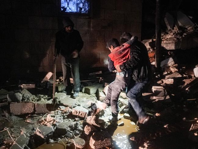 A man carries away an injured child in the town of Jandaris, Syria. Picture: AFP