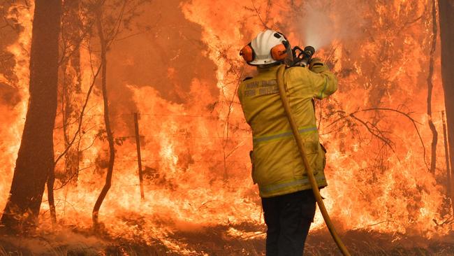 A firefighter conducts back-burning operations on the NSW central coast on Tuesday. Picture: AFP