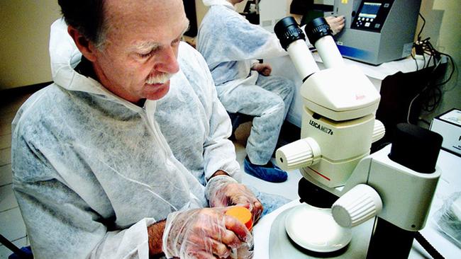 Then AFP forensic team leader David Royds prepares to examine some minute evidence under the microscope in a makeshift forensic right laboratory at the AFP Bali Headquarters in November, 2002. Picture: AFP