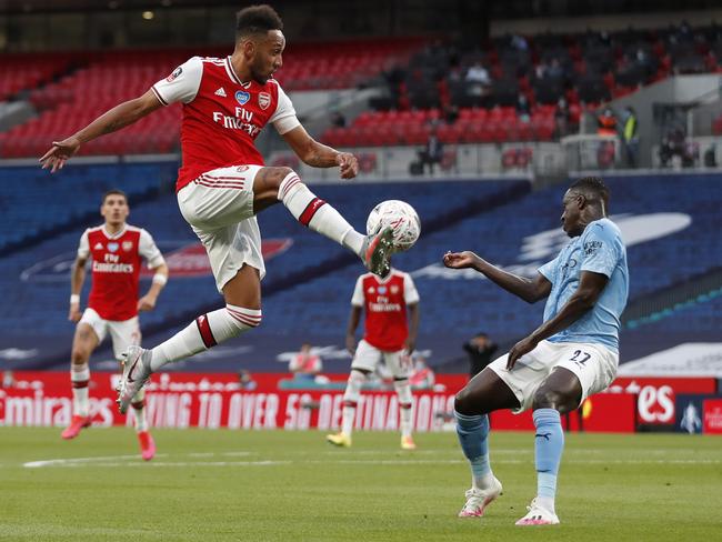 LONDON, ENGLAND - JULY 18: Pierre-Emerick Aubameyang of Arsenal jumps for the ball whilst Benjamin Mendy of Manchester City attempts to block during the FA Cup Semi Final match between Arsenal and Manchester City at Wembley Stadium on July 18, 2020 in London, England. Football Stadiums around Europe remain empty due to the Coronavirus Pandemic as Government social distancing laws prohibit fans inside venues resulting in all fixtures being played behind closed doors. (Photo by Matthew Childs/Pool via Getty Images)