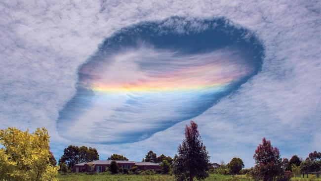 MUST MENTION 2016 Australian Weather Calendar MUST CREDIT PHOTOGRAPHER July - Fallstreak hole over Korumburra, Vic (David Barton) David Barton and his wife spotted a rare phenomenon over eastern Victoria on 3 November 2014. Fallstreak holes, or hole punch clouds, form in clouds that contain supercooled water droplets—at a temperature below freezing point, but not frozen. A trigger such as a passing aircraft causes ice crystals to form, and a chain reaction makes water droplets around those crystals evaporate, leaving a ‘hole’ around the wispy patch of ice crystals. Sunlight passing through this thin part of the cloud is refracted, or bent, with different wavelengths (i.e. colours) spreading out in a similar way to how rainbows form. This is called cloud iridescence or irisation. David took this shot from his front porch, with a Nikon D7100 and an 18–140mm lens.