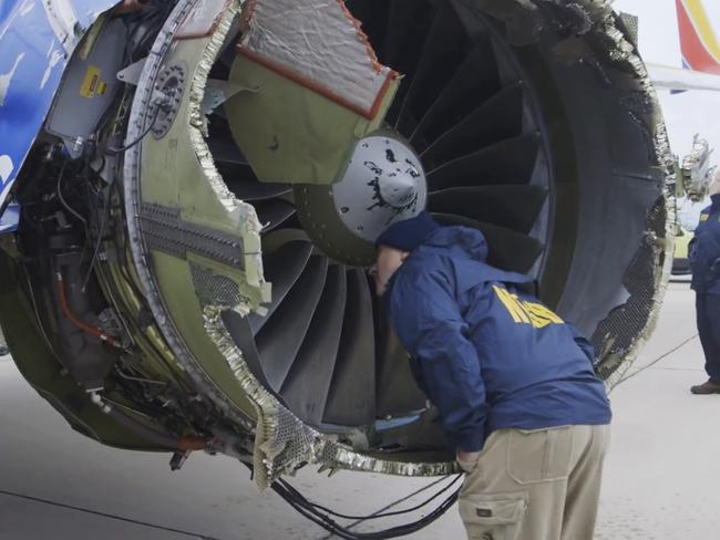 A National Transportation Safety Board investigator examines damage to the engine of the Southwest Airlines plane. Picture: NTSB