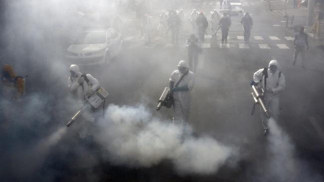 Iranian Firefighters disinfect streets in the capital of Tehran in a bid to halt the wild spread of the virus. Picture: AFP