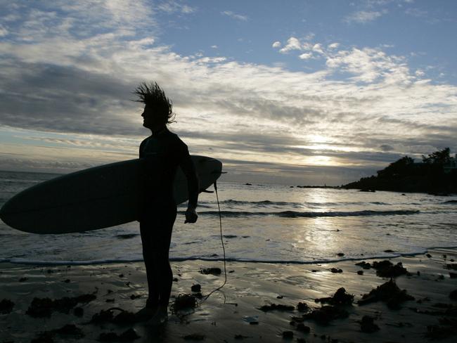 Pepperdine University student Ryan Bumpas shakes the water out of his hair after coming in from an afternoon of surfing at Broad Beach in Malibu, Calif. on Jan. 6, 2005. Bumpas, who surfs there regularly, has never been harrassed by residents for using the beach. (AP Photo/Laura Rauch)