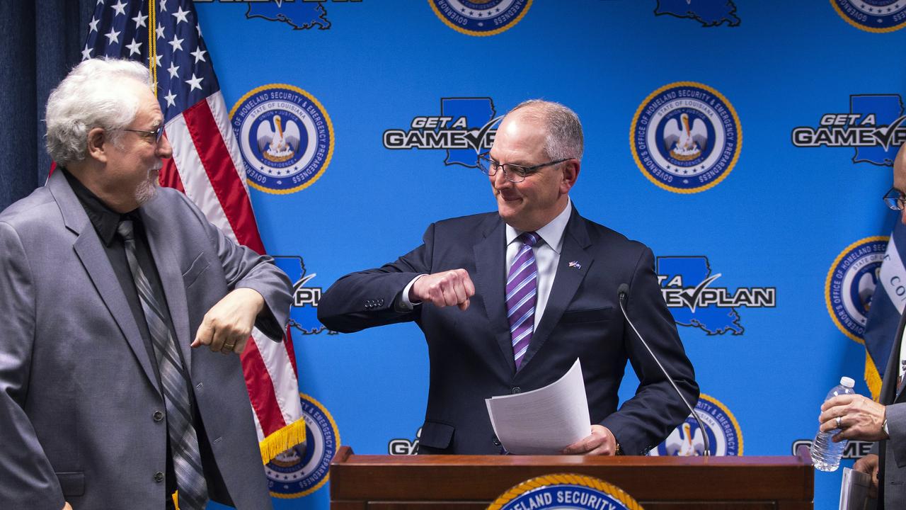 Governor John Bel Edwards substitutes an elbow bump for the customary handshake when greeting Daniel Burch in the US. Picture: Travis Spradling/The Advocate via AP