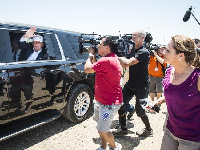 Donald Trump talks to media from his car wearing a “Make America Great Again” hat. Picture: AFP