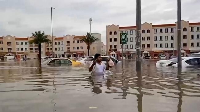 A man wades through a flooded street in Dubai. Picture: Atif Bhatti/ESN/AFP