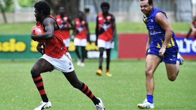 Ross Tungatalum runs away from Shannon Motlop in the NTFL.