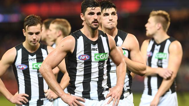 Scott Pendlebury leads Collingwood off after the loss to Melbourne.