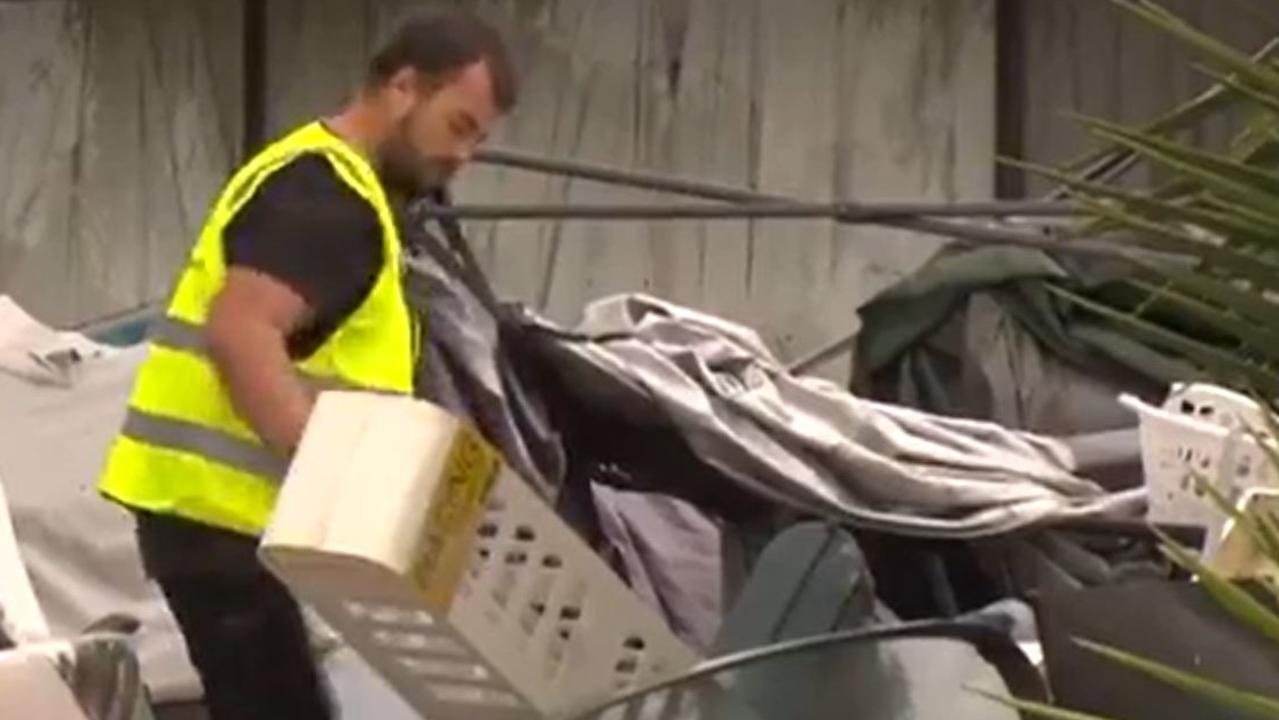 A man is seen removing items from the front yard. Picture: 7News