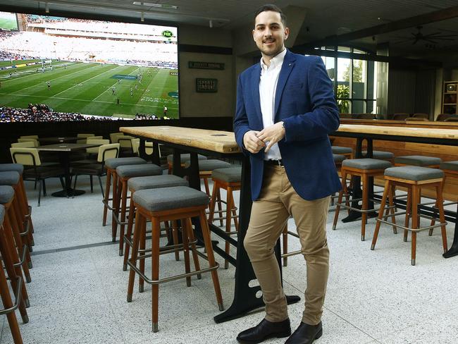 Venue manager Hayden Elvy in front of the main sports screen, the biggest on the northern beaches. Picture: John Appleyard