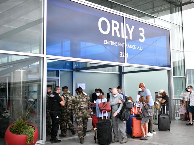 Travellers, wearing protective face masks at a Paris airport during the peak pandemic. Masks will no longer be mandatory in Europe. Picture: AFP.