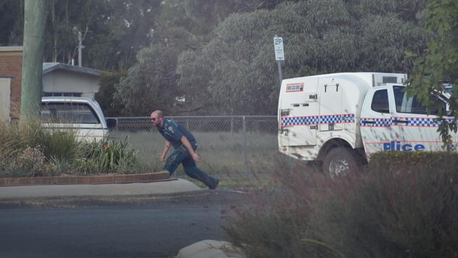 A paramedic runs from gunfire in Tara. Picture: Chloe Cufflin