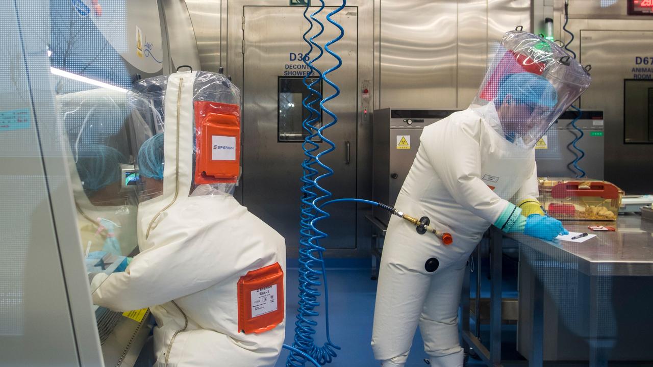 Workers next to a cage with mice (R) inside the P4 laboratory in Wuhan, the capital of China's Hubei province.