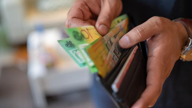 a male taking money out of a wallet, Australian cash generic spending