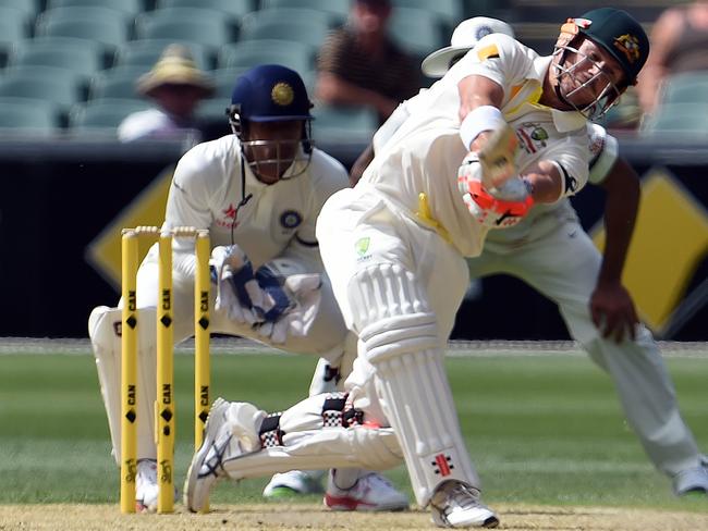 David Warner attacks the ball during his century on day one of the first Test. AFP PHOTO / SAEED KHAN.