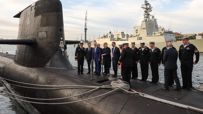 French President Emmanuel Macron and Australian Prime Minister Malcolm Turnbull on the deck of HMAS Waller with Royal Australian Navy sailors. Picture: AFP / Ludovic Marin