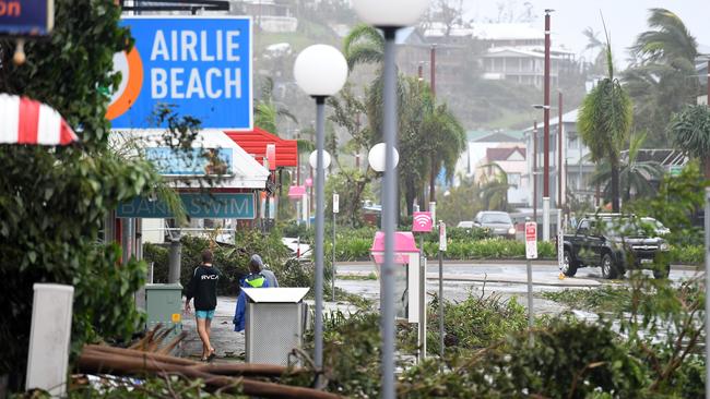 A large tree blocks a footpath in Airlie Beach, where stranded tourists are becoming angry. Picture: AAP