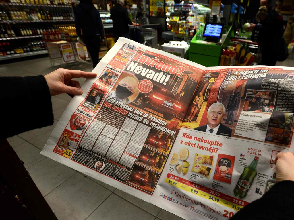 A woman reads an article in the "Blesk" Czech tabloid newspaper with images of the Minister of Health of the Czech Republic Roman Prymula allegedly dining at a restaurant despite the recent coronavirus restrictions in Prague, on October 23, 2020. Picture: Michal Cizek/AFP