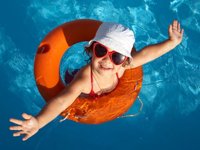 Generic Thinkstock image of a young girl in a swimming pool wearing a red rubber floaty, smiling with arms out.