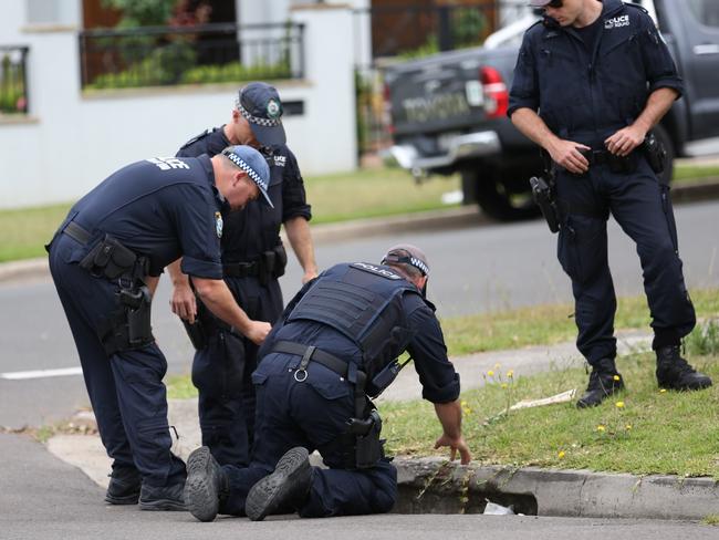 Police search for clues at the shooting scene today. Picture: Steve Tyson