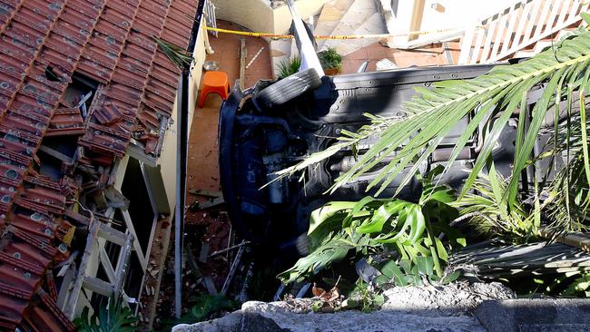 Car falls into back yard hitting roof on the way down in Manly.