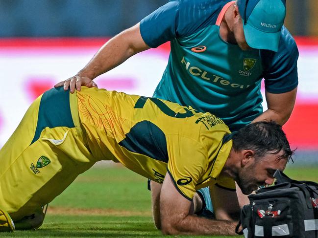 Australia's Glenn Maxwell (bottom) is being attended by a physio during the 2023 ICC Men's Cricket World Cup one-day international (ODI) match between Australia and Afghanistan at the Wankhede Stadium in Mumbai on November 7, 2023. (Photo by INDRANIL MUKHERJEE / AFP) / -- IMAGE RESTRICTED TO EDITORIAL USE - STRICTLY NO COMMERCIAL USE --