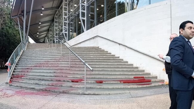 Protesters dyed the steps of the Brisbane Convention and Exhibition Centre with 'blood' on the first day of the Land Forces Conference. Picture: Disrupt Land Forces