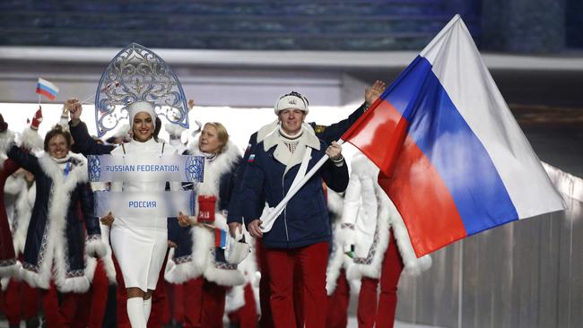 FILE - In this Feb. 7, 2014 file photo Alexander Zubkov of Russia carries the national flag as he leads the team during the opening ceremony of the 2014 Winter Olympics in Sochi, Russia. When the International Olympic Committee board prepares to vote Tuesday, Dec. 5, 2017 on whether to ban Russia from Februaryâ€™s Winter Olympics, its members will decide the fate of numerous medals yet to be won. (AP Photo/Mark Humphrey, file)