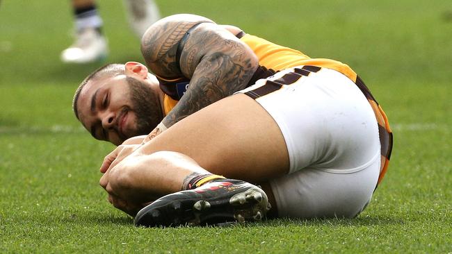 Jarman Impey clutches his knee after an awkward landing at the MCG.