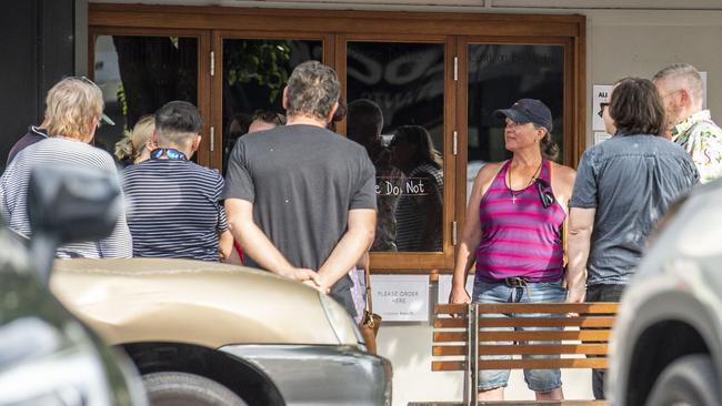 People gather on footpath near Bar Wunder after police ordered the bar to close. Thursday, December 23, 2021. Picture: Nev Madsen.