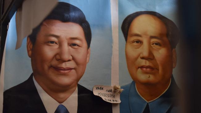 Portraits of Xi Jinping and Mao Zedong are seen at a market in Beijing.