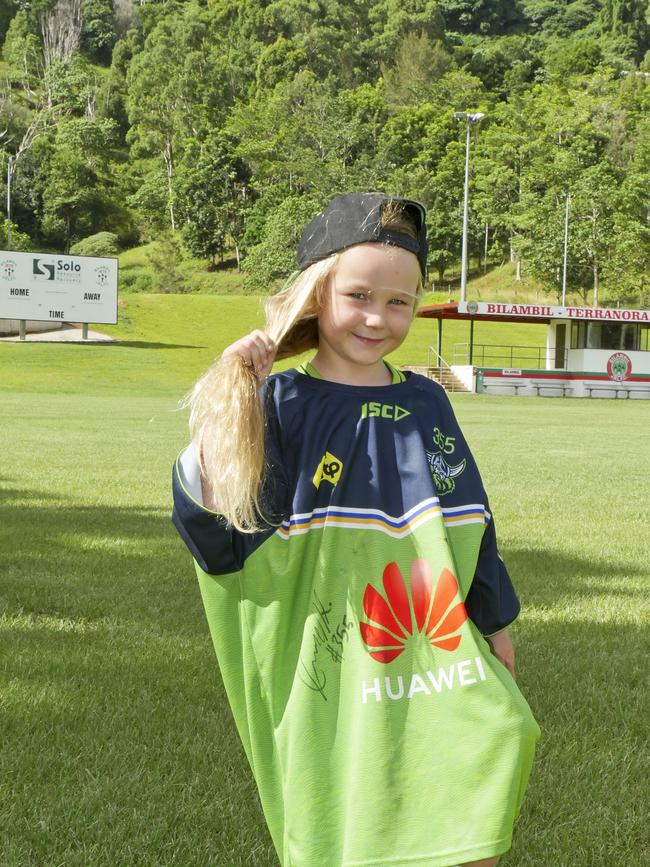 Bilambil Jets Junior Rugby League player and Canberra Raiders super fan Nina Clarke, 4, will be shaving off her hair for cancer at her first rugby match later this month. She is wearing a training shirt her hero and favourite player Charnze Nicoll-Klokstad gave her when he heard about her World's Greatest Shave event.