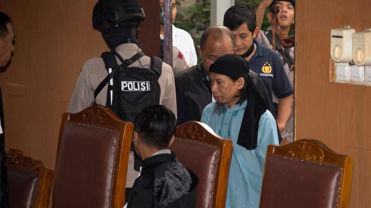 Indonesian anti-terror police officers escort Aman Abdurrahman (in light blue), now on death row awaiting execution. Picture: AFP