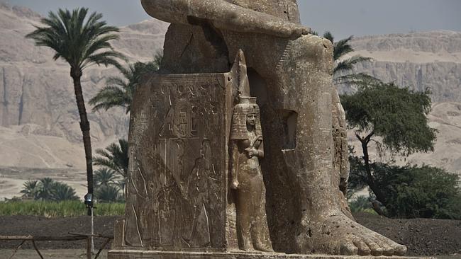 Seat of kings ... The new statue of pharaoh Amenhotep III and his wife Tiye join the existing two famous ancient Memnon colossi in Luxor. Picture: Khaled Desouki