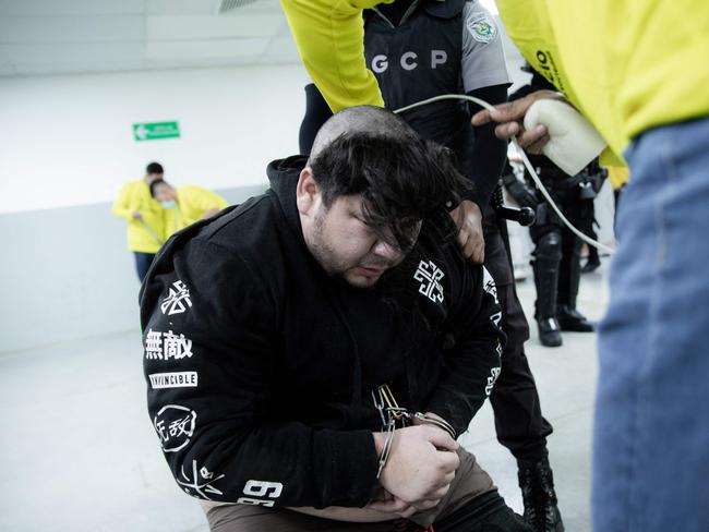 An accused gang member has his head shaved upon his arrival at the jail. Picture: AFP