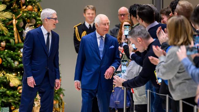 Britain's King Charles III (C) with Chief Executive of Apple, Tim Cook (L), visits the firmâs UK headquarters, in London, on December 12, 2024. (Photo by Paul Grover / POOL / AFP)