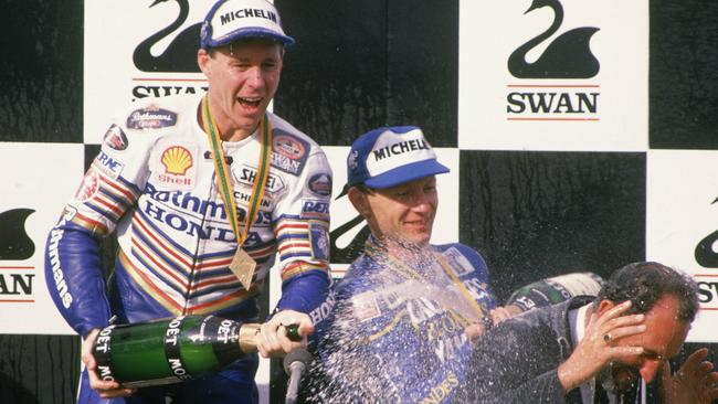 Promoter Bob Barnard gets showered with champagne during Wayne Gardner’s victory celebrations.