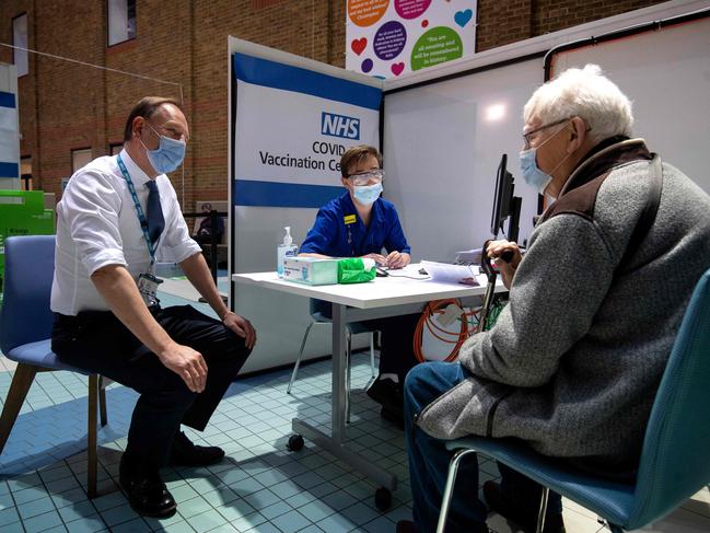 Simon Stevens, left, Chief Executive of the NHS, talks with a patient who is attending a vaccination centre to receive a dose of the Pfizer-BioNTech Covid-19 vaccine at Guy's Hospital in London.