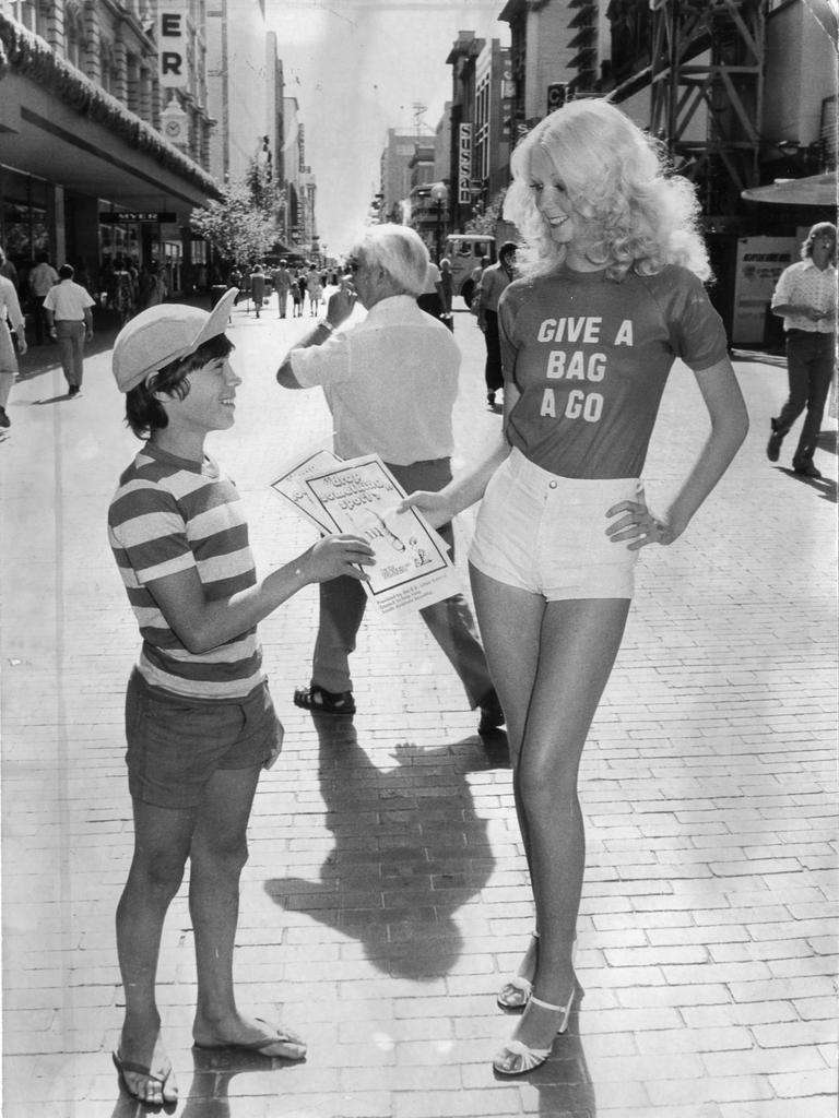 Model Debbie Mead, 16, hands 12-year-old David Buhagiar a KESAB rubbish bag in a campaign to pick up litter in 1977.